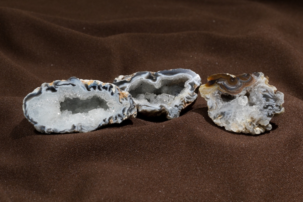 The interior of the same 3 small geodes showing all the crystals and different colors inside.