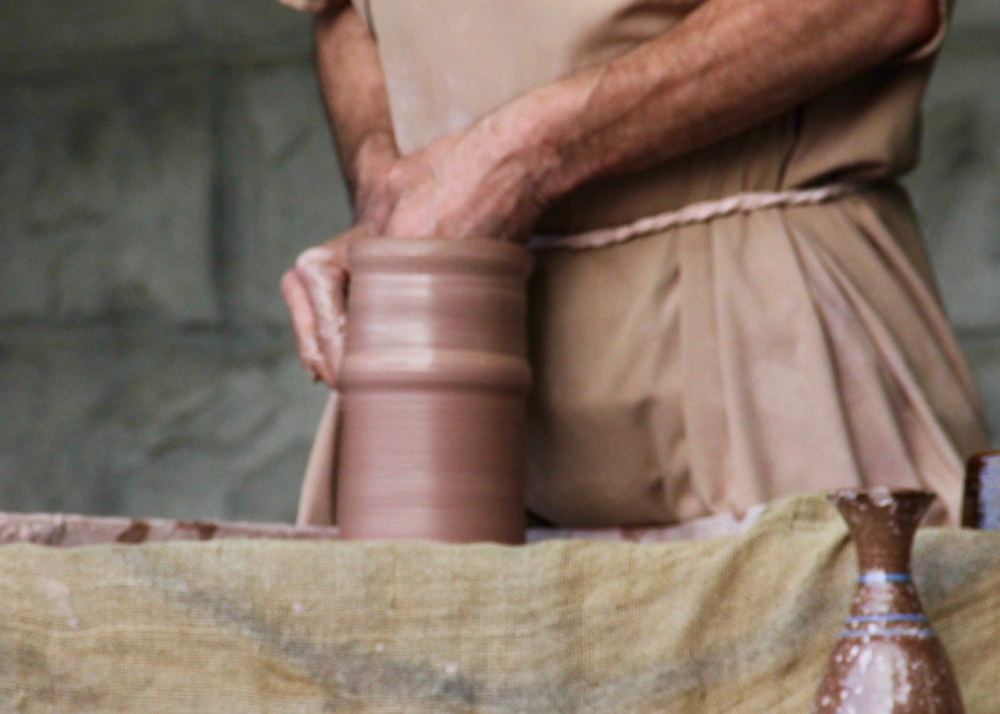 A potter's hand shaping clay.