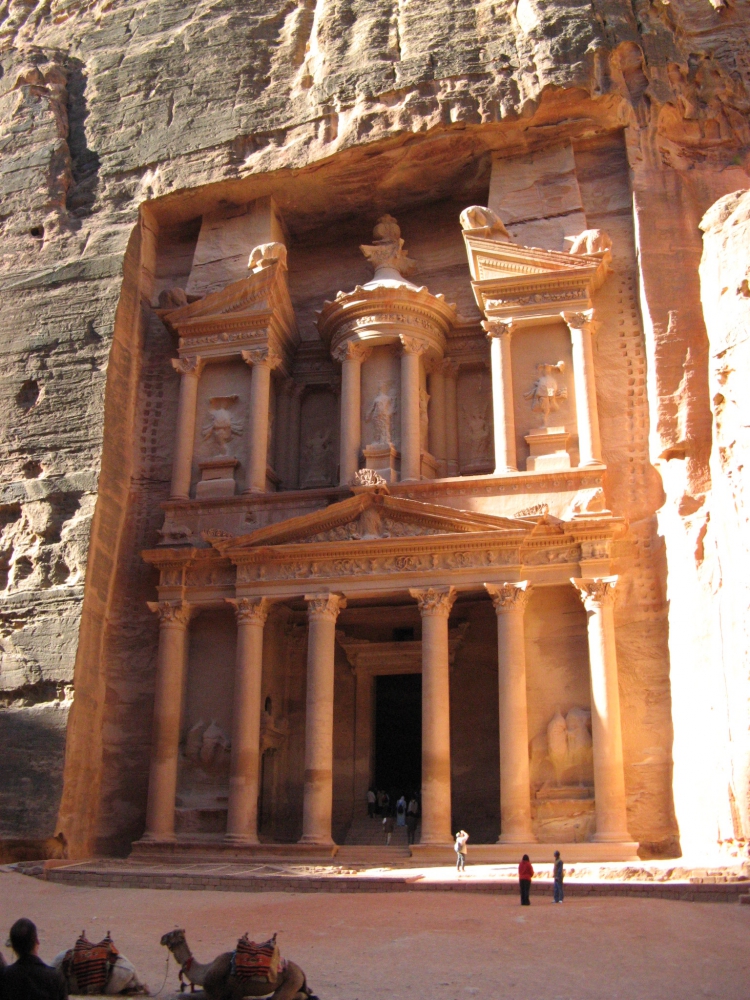 Petra's large Treasury of hand carved sandstone looking a pinkish gold in the afternoon sunlight.