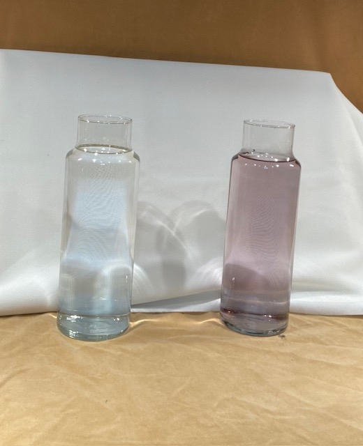 A white background behind two glass columns of water that shows how dingy the one on the right is next to the pure one on the left.