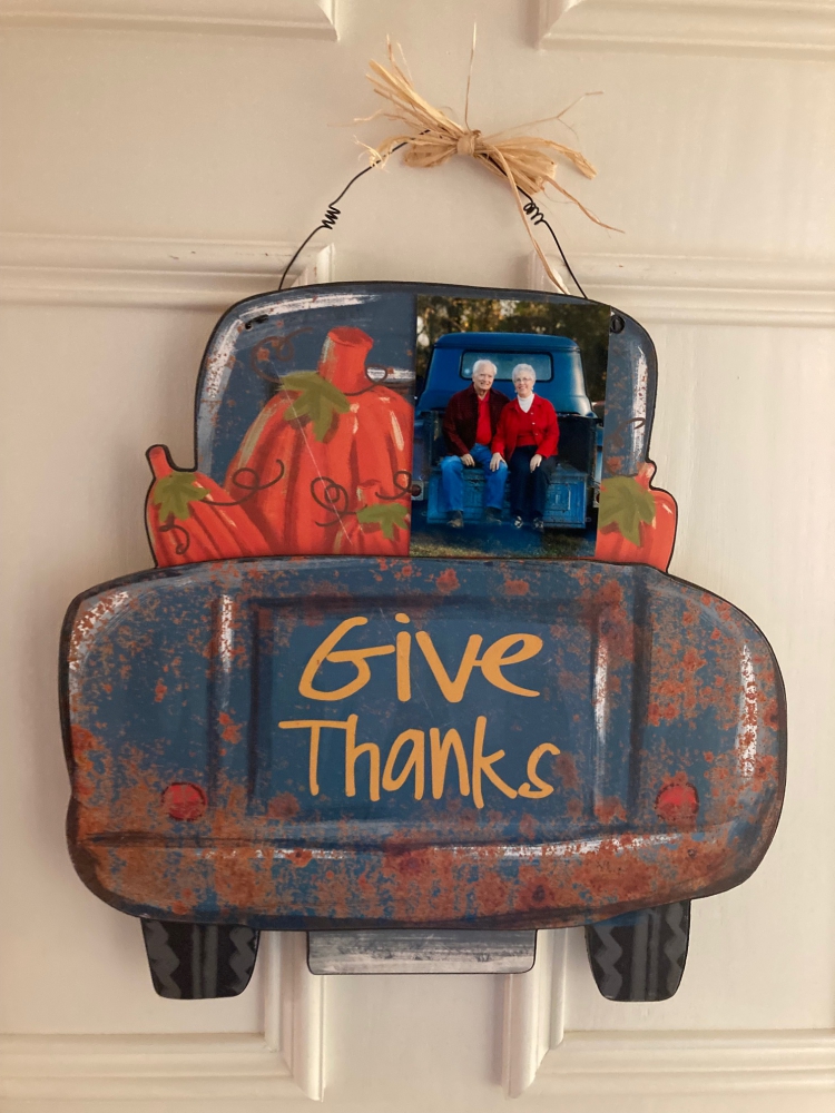 An antique truck loaded with pumpkins and having 