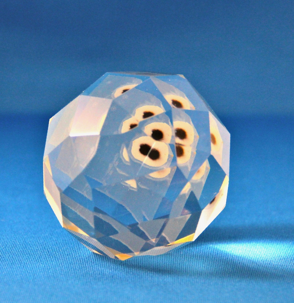 crystal paperweight reflecting many black spots.