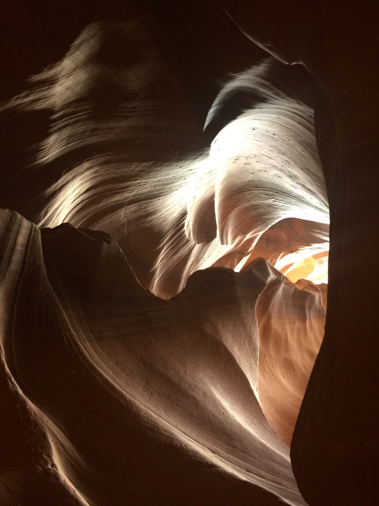 Range of orange to black colors on swirling cuts in rock face of Upper Antelope Slot Canyon.