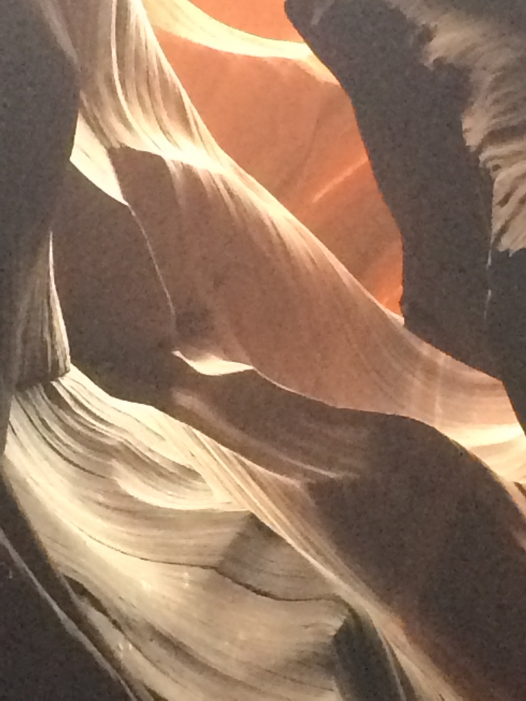 Range of orange to tan colors from sunlight on shaped sandstone rocks in Antelope Slot Canyon.