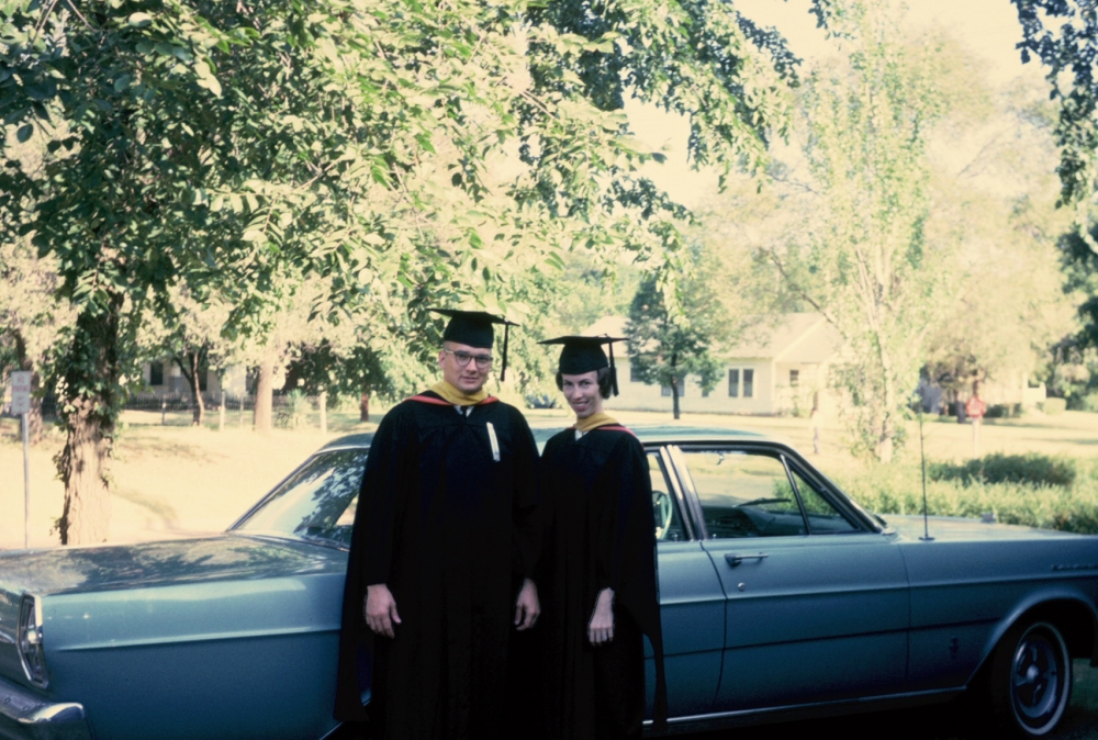 Young couple in front of their new car.