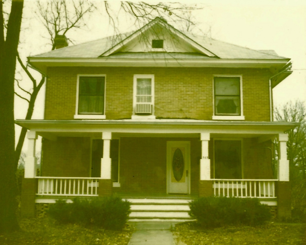 Old three story brick house with oval front door.