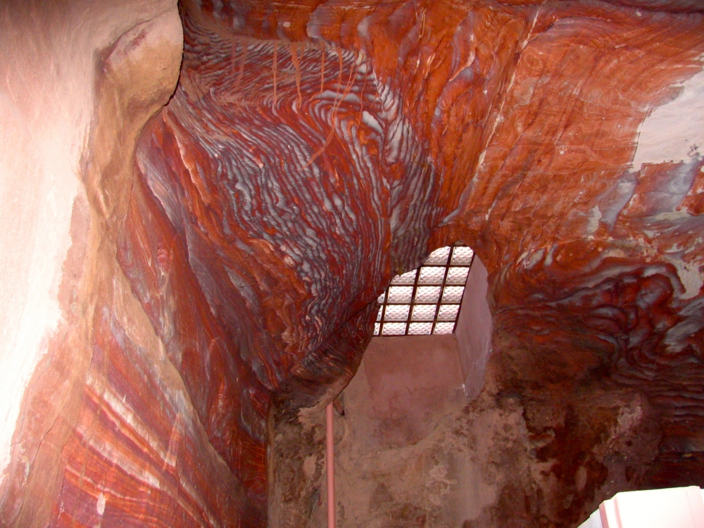 Colorful streaked sandstone around a ceiling vent in bathroom at Petra.