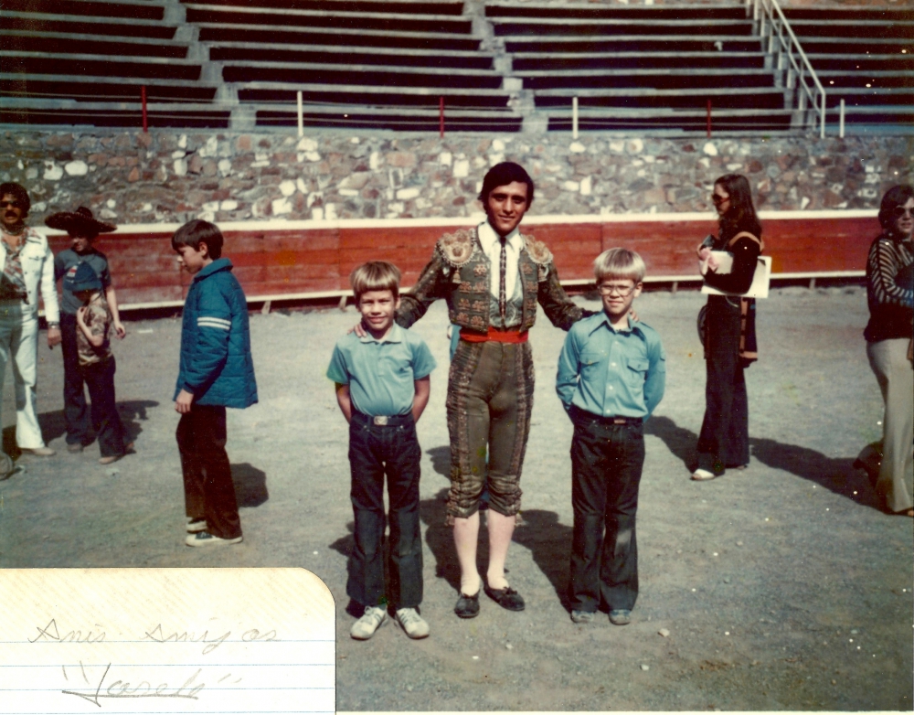 The author's two young sons standing with a matador dressed in his costume.